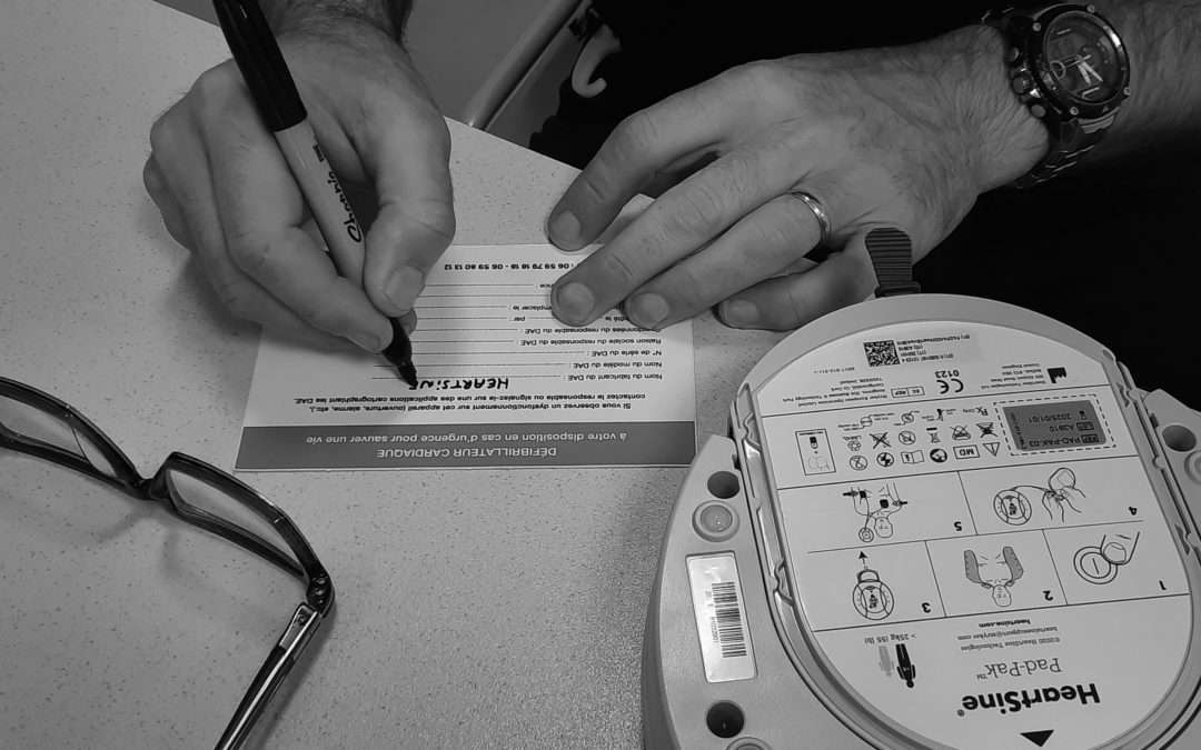 Technicien remplissant une fiche de maintenance d’un défibrillateur automatisé externe