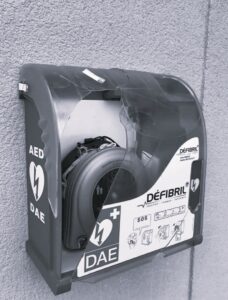 Boîtier de défibrillateur DAE fissuré fixé à un mur, contenant un appareil HeartSine Samaritan