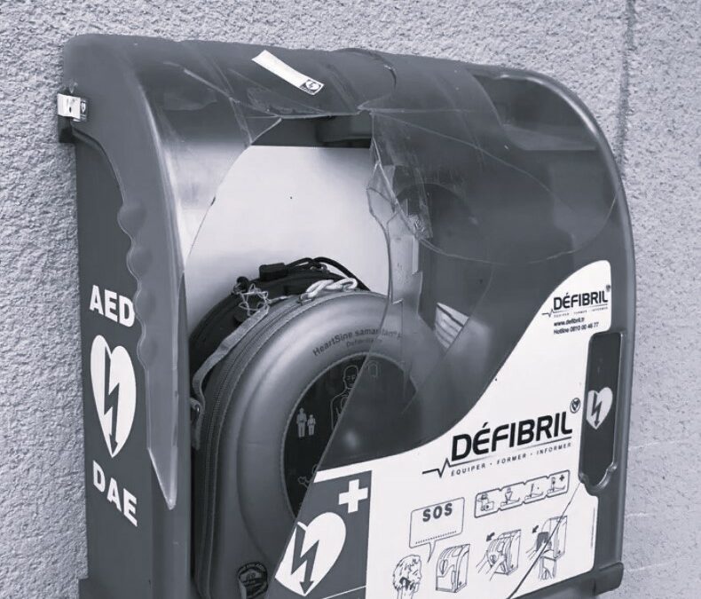 Boîtier de défibrillateur DAE fissuré fixé à un mur, contenant un appareil HeartSine Samaritan